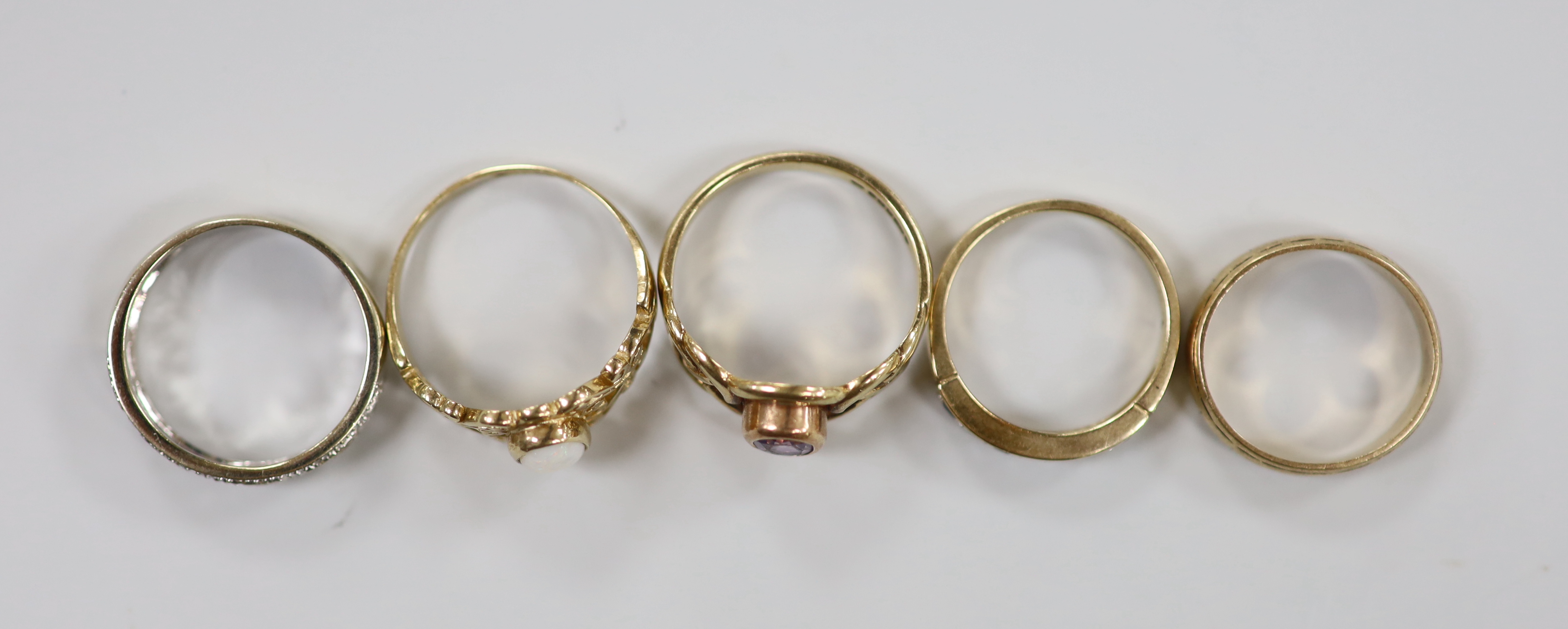 Four assorted modern 9ct gold and gem set dress rings, including single stone amethyst and singe stone white opal, together with a 9ct gold band, gross weight 13.5 grams.